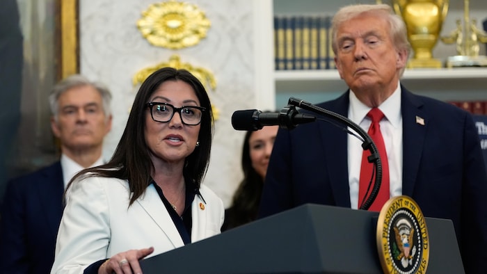 Donald Trump et Lori Chavez-DeRemer derrière un lutrin.
