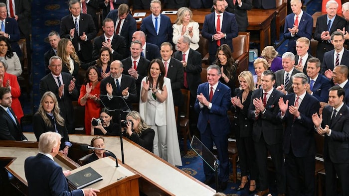 M. Trump de dos devant les premiers rangs des élus du Congrès qui l'applaudissent.