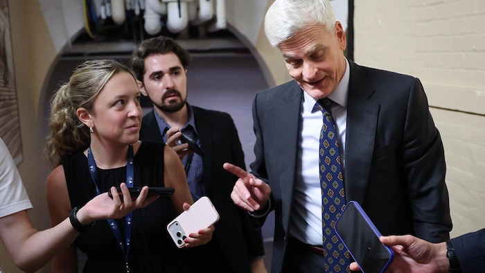 Bill Cassidy répond aux questions des médias et agite le doigt.