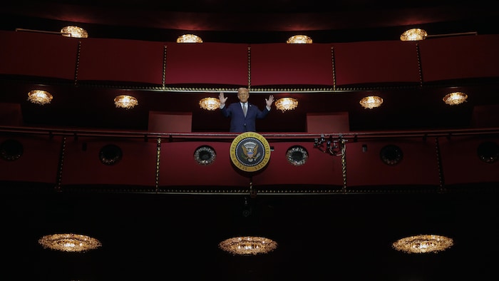 Un homme se tient debout dans un théâtre.