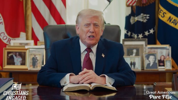 Donald Trump parle, assis dans le bureau ovale.