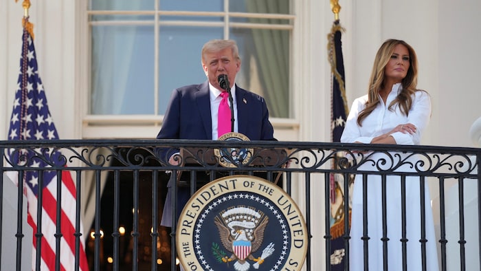 Un homme s'adresse à une foule depuis un blacon.