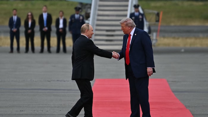 Donald Trump et Vladimir Poutine se serrent la main sur le tarmac.