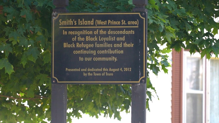 Une plaque noire et or en anglais expliquant ce qu'est Smith's Island.