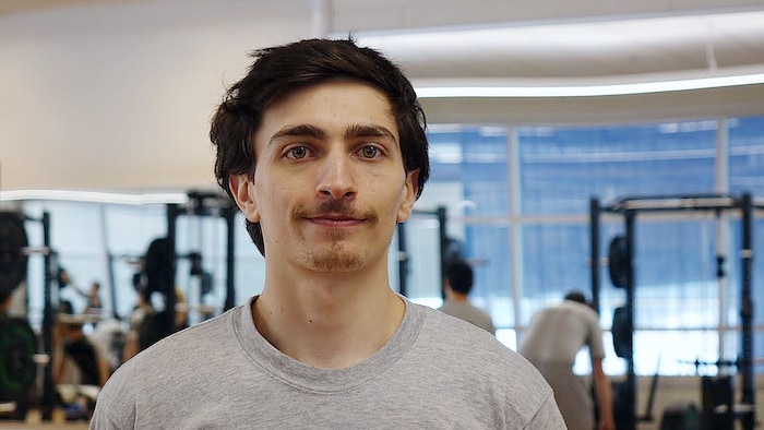 Jeune homme en t-shirt à la salle d'entraînement.