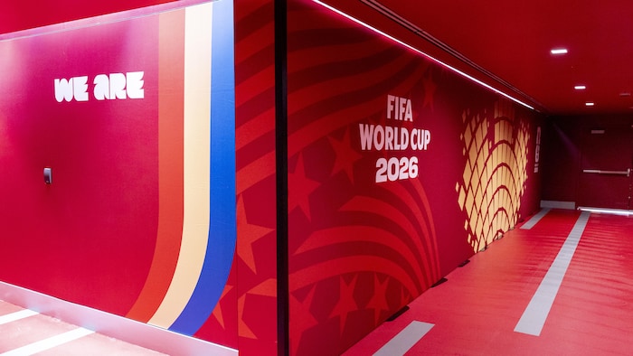 Un corridor donnant sur une porte ouverte sur l’extérieur aux couleurs de la Coupe du monde de la FIFA.