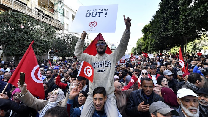 Une foule tient des pancartes, dont une sur laquelle est écrit : « Kaïs Saëd, dehors! »