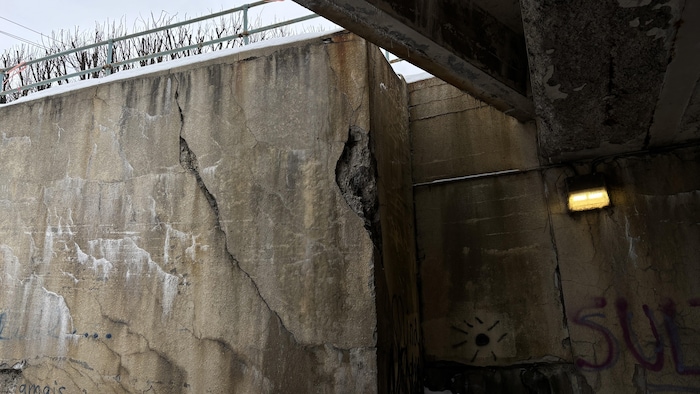 La structure de béton d'un tunnel comporte des fissures.