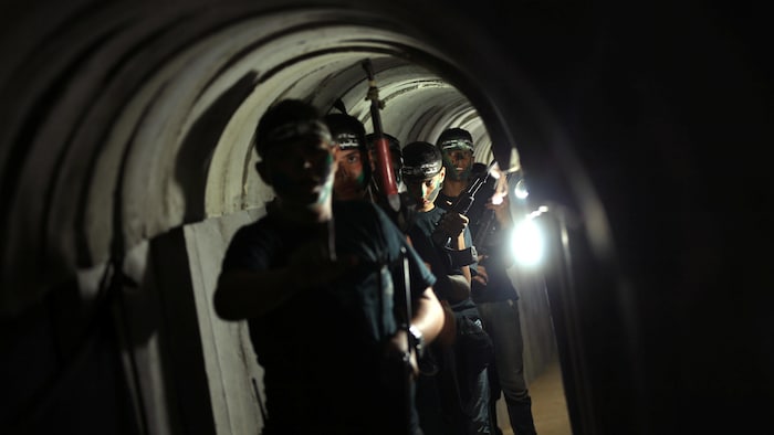 Six soldats armés dans un tunnel.