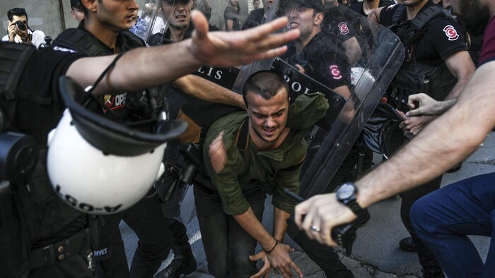 Un manifestante turco es empujado por agentes de policía durante una protesta LGBT en Estambul.