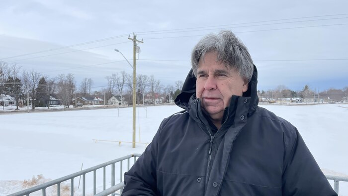 Homme debout devant un terrain de soccer enneigé
