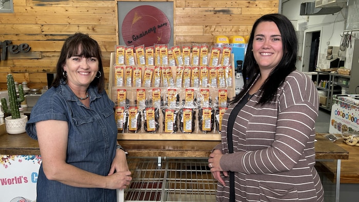 Twila Wedrick et Shianna Smart sont debout devant un présentoir de leurs produits.
