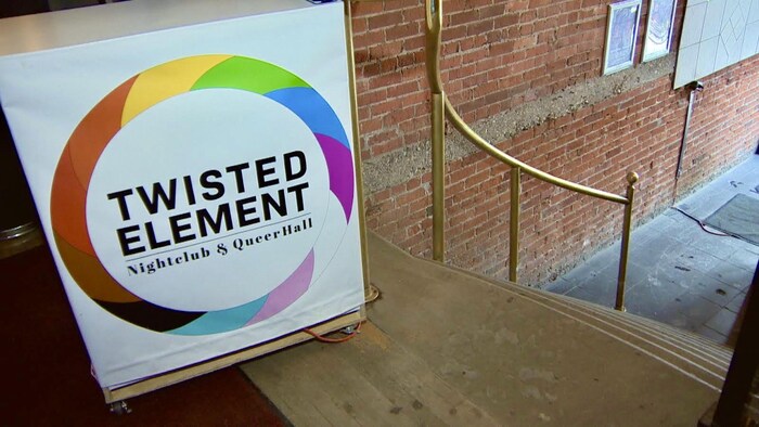 Une pancarte avec le logo de Twisted Element devant un escalier.