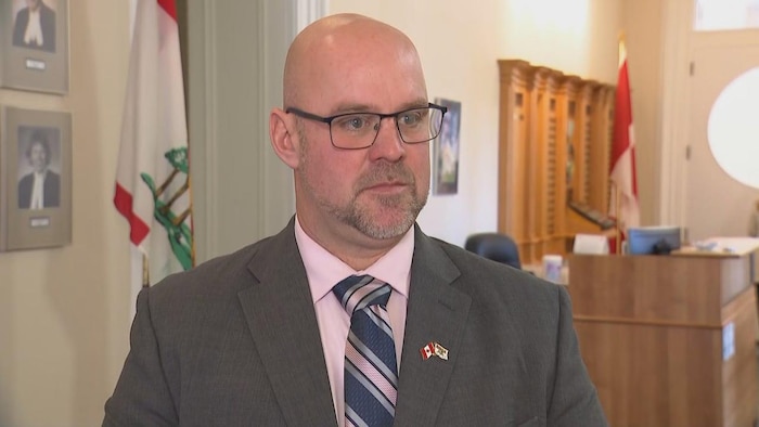 Un homme en complet dans l'édifice de l'Assemblée législative.