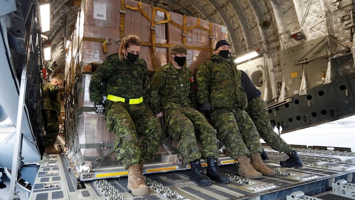Des soldats canadiens chargent de l'aide militaire non létale pour l'Ukraine. (7 mars 2022) 