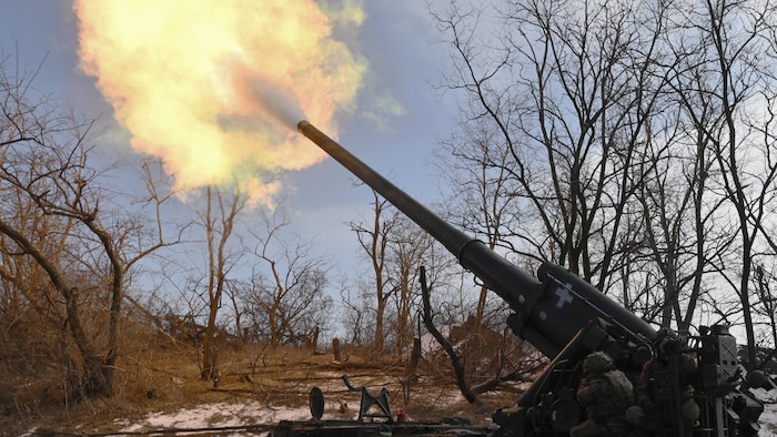 Des militaires ukrainiens tirent avec un canon.