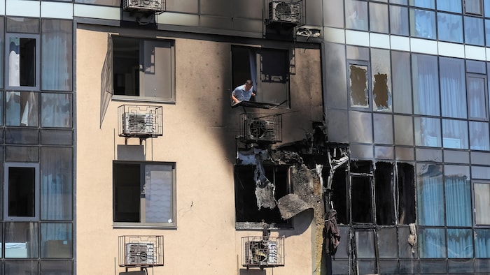 Un habitant regarde par la fenêtre d'un immeuble qu'une frappe de drone russe a endommagé, à Odessa, le 1er&nbsp;août&nbsp;2026. 