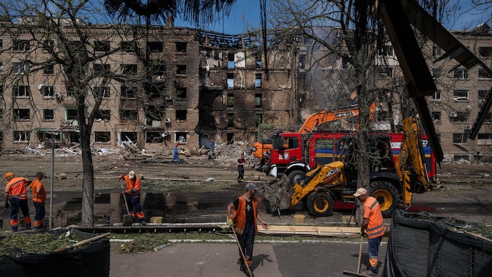 Des agents municipaux de Kiev nettoient une zone de la ville après des frappes russes par missiles et drones.