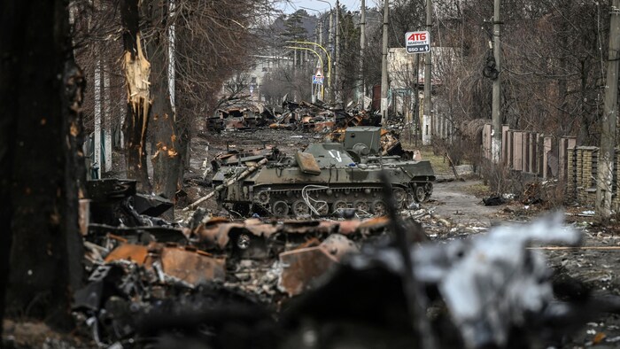 Una calle llena de tanques militares quemados.