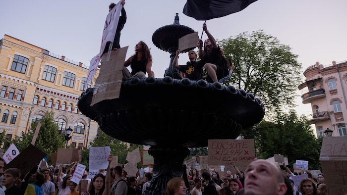 Des manifestants brandissent des pancartes lors d'une manifestation contre une loi qui supprime l'indépendance de deux organismes clés de lutte contre la corruption dans le centre-ville de Kiev, le 23 juillet 2025.