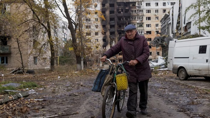 Un homme dans une rue jonchée de débris.