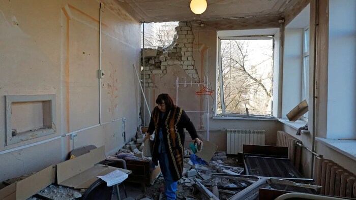 A woman who identified herself as Svetlana removes debris from a ward of a hospital hit by Russian shelling in Donetsk. (Alexander Ermochenko/Reuters)