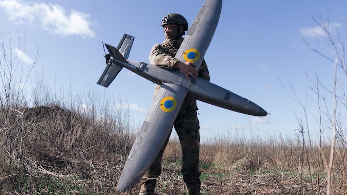 Un soldat de l'unité de drones « Taifun » tenant un nouveau modèle de drone d'attaque « Marsianin », dans la région de Kharkiv, en Ukraine.