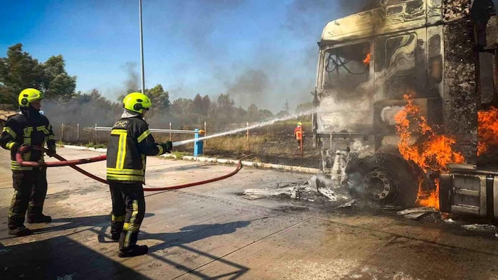 Des pompiers interviennent sur les lieux d'une frappe russe, à Kiev.