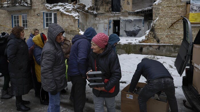 Ukrainians line up to receive food on November 22, 2022 in Horenka.