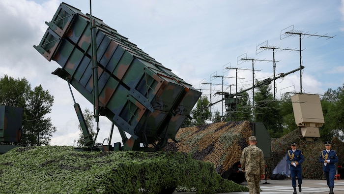 Des soldats marchent près d'un système de défense sol-air Patriot.