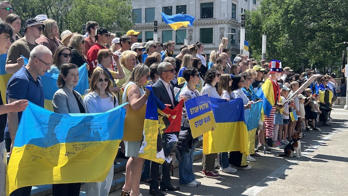 Des personnes en rang, certaines avec un drapeau ukrainien.
