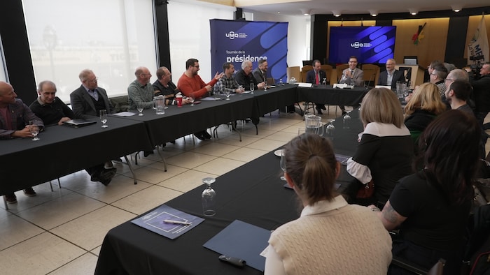 Plusieurs personnes réunies autour d'une grande table.