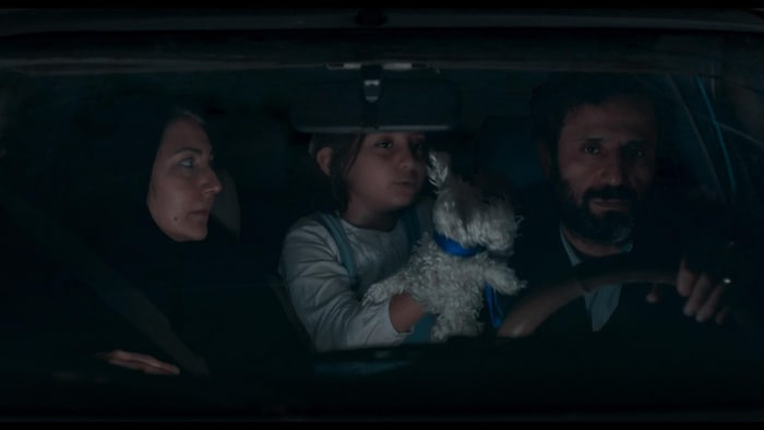 Une scène du movie  avec trois personnes dans une voiture.