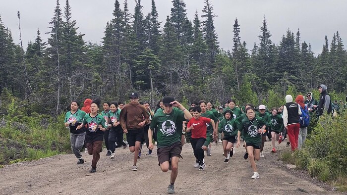 Plusieurs jeunes athlètes courent dans les bois.