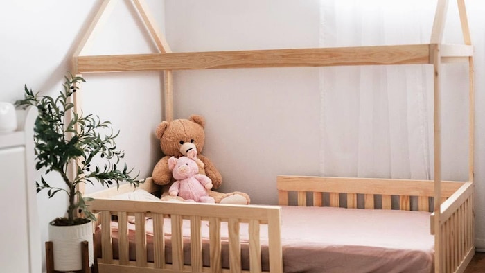 Un lit pour enfant en bois doté d'une canopée.