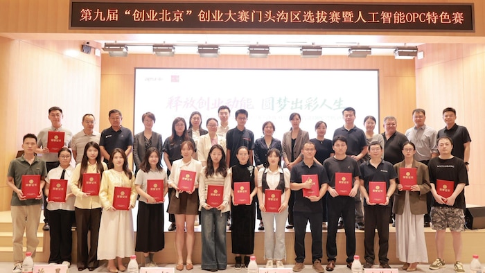 De jeunes entrepreneurs chinois posent avec un document rouge dans les mains.