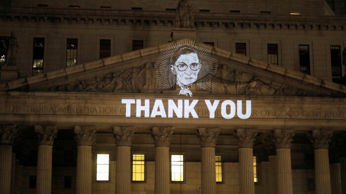Une image de la juge Ruth Bader Ginsburg projetée sur la façade de la Cour suprême de l'État de New York à Manhattan, avec la mention « Thank you ». 
