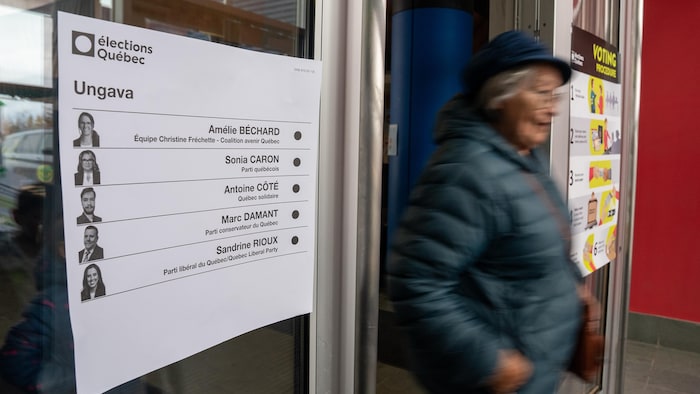 Une dame sort du bureau de vote.