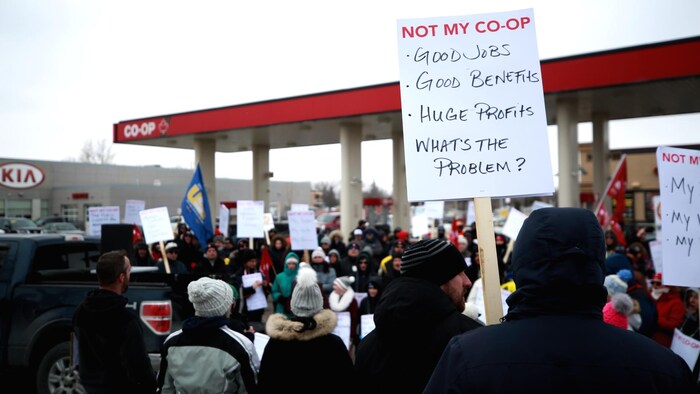 Des personnes manifestent à l'extérieur tout près d'une station-service Co-op.