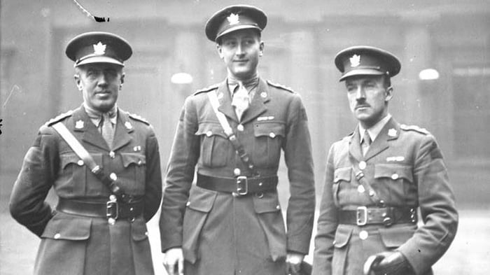 Trois soldats portant des chapeaux et des uniformes de l'armée canadienne dans une photo d'antan. 