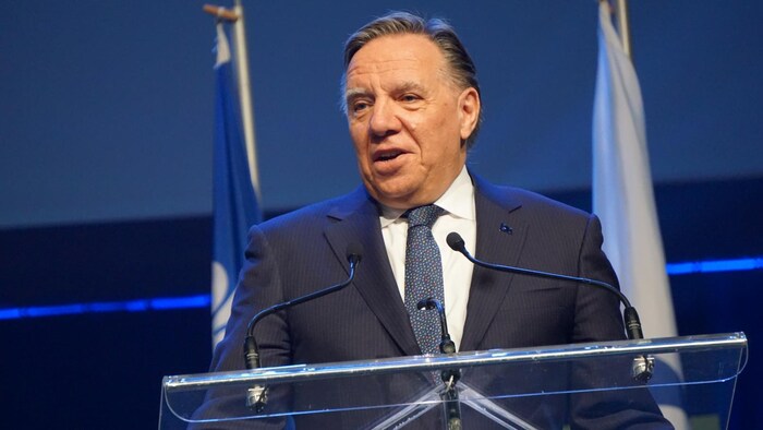 François Legault s'exprime sur scène derrière un lutrin.