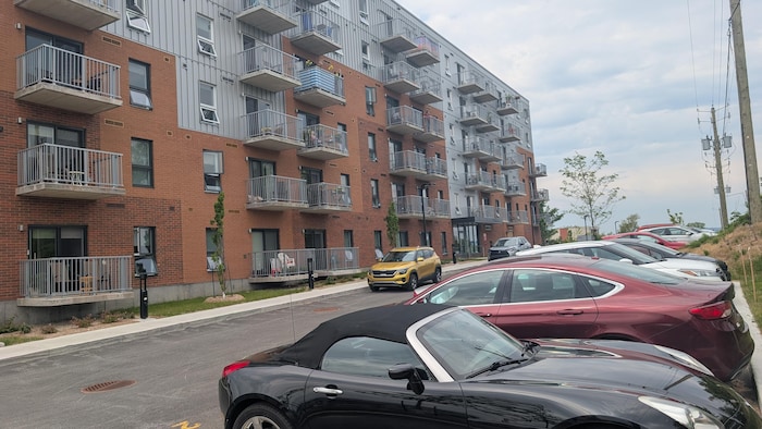 Des voitures stationnées devant un immeuble.