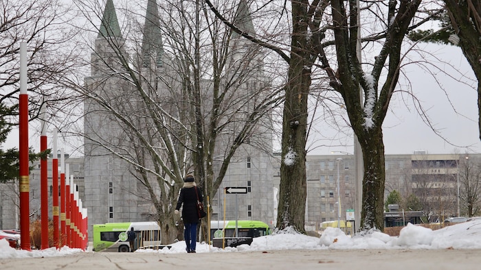 Une étudiante se promène en hiver sur le campus. 
