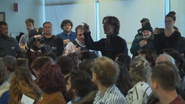 Un homme s'exprime devant une foule.