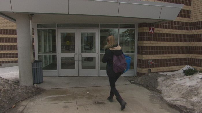 Une étudiante entre dans un édifice du campus de Moncton
