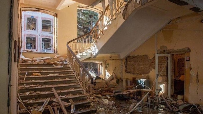 Un escalier est recouvert de morceaux de mur et de plafond.