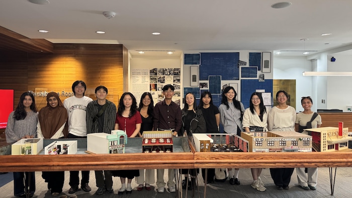Des diplômés et étudiants en architecture de l'Université de Waterloo devant les maquettes de restaurants du quartier chinois qu'ils ont faites, aux Archives de Toronto, le vendredi 28 août 2026.