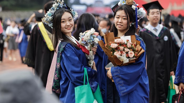 两个女孩在拍毕业照片。