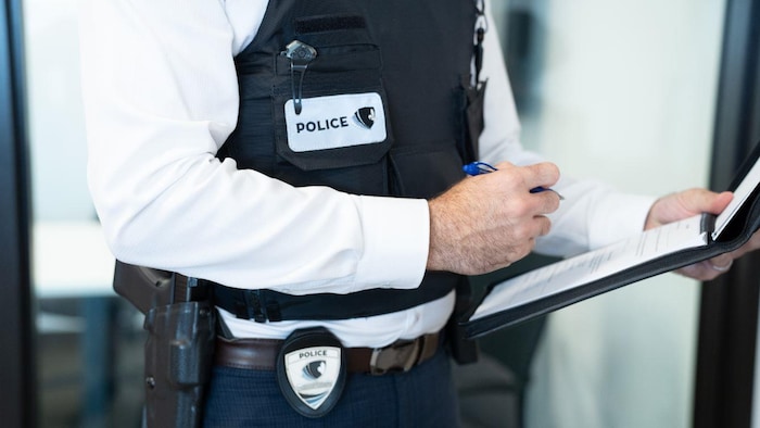 Un policier prend des notes sur sa feuille.