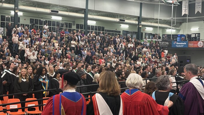 Dignitaires, étudiants et invités debout.